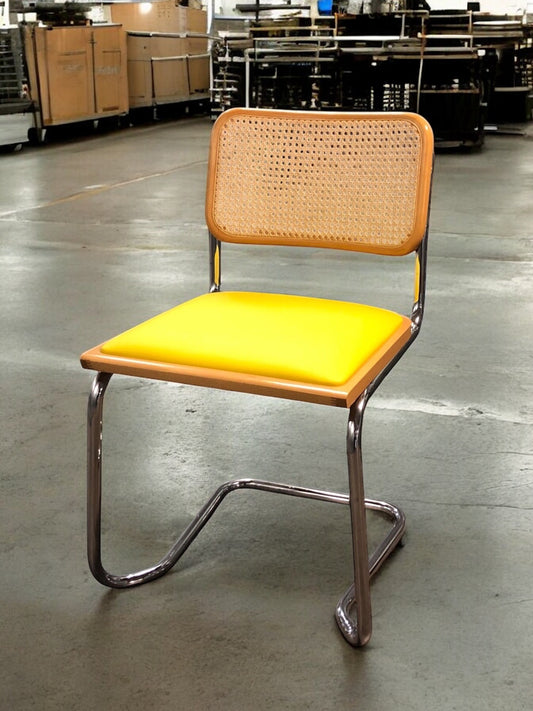Rottingstol Klassisk Bauhausstolar med fodrad gul konstläder sits och rotting rygg.
Sits märkt "Made in italy". 
Bra begagnat skick och stapelbar. Cesca  stol med flätad rotting. Designstol i klassisk stil. 
Designstol Frisvinger karmstol i klassiska design.
Höjd: ca 84,5 cm
Bredd: ca 48 cm
Djup: ca 52cm
Sitthöjd: ca 49 cm