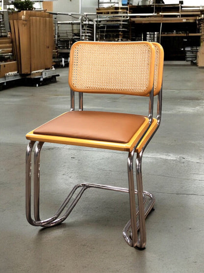 Rottingstol Klassisk Bauhausstolar med fodrad ljusbrun konstläder sits och rotting rygg.
Sits märkt "Made in italy". 
Bra begagnat skick och stapelbar. Cesca  stol med flätad rotting. Designstol i klassisk stil. 
Designstol Frisvinger karmstol i klassiska design.
Höjd: ca 84,5 cm
Bredd: ca 48 cm
Djup: ca 52cm
Sitthöjd: ca 49 cm