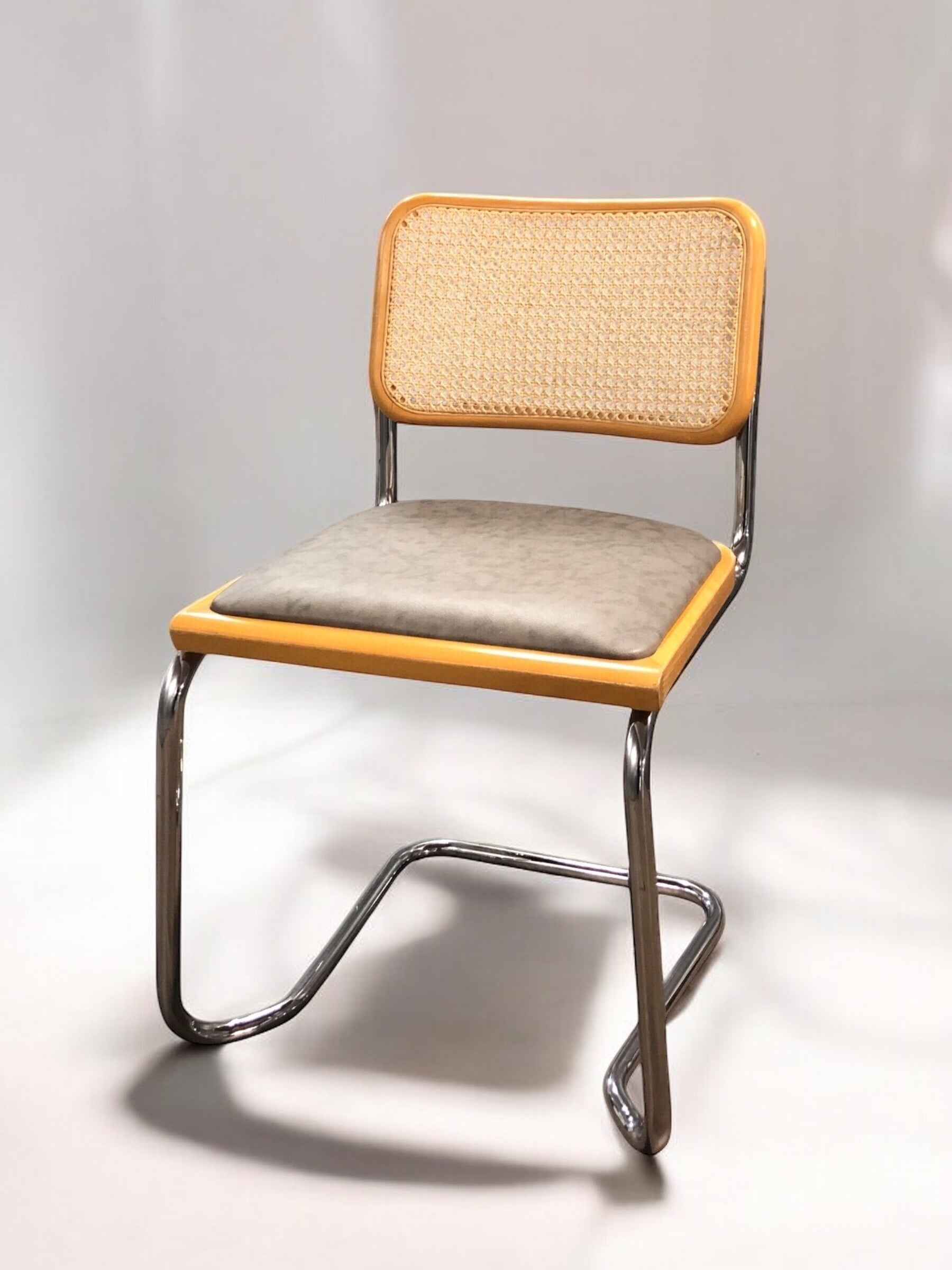 Rottingstol Klassisk Bauhausstolar med fodrad gråmelerad konstläder sits och rotting rygg.
Sits märkt "Made in italy". 
Bra begagnat skick och stapelbar. Cesca  stol med flätad rotting. Designstol i klassisk stil. 
Designstol Frisvinger karmstol i klassiska design.
Höjd: ca 84,5 cm
Bredd: ca 48 cm
Djup: ca 52cm
Sitthöjd: ca 49 cm