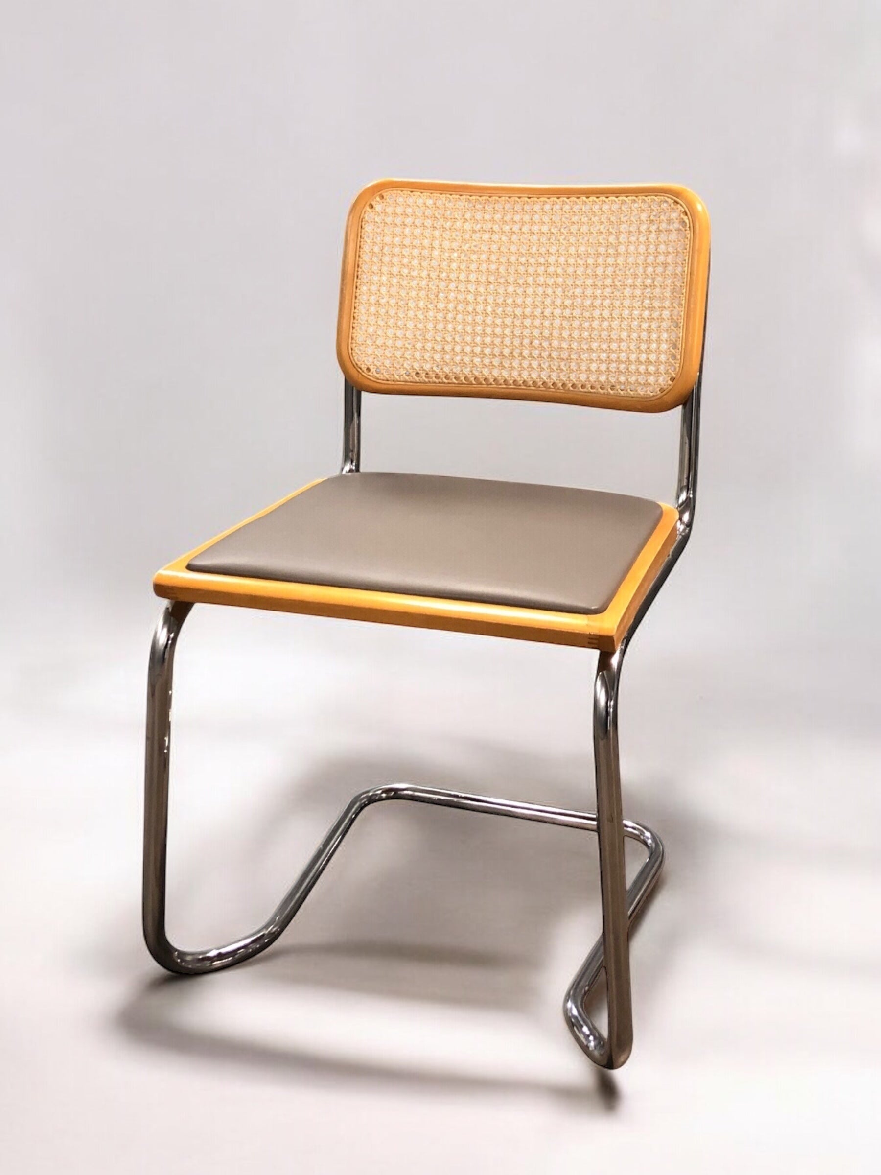Rottingstol Klassisk Bauhausstolar med fodrad grå konstläder sits och rotting rygg.
Sits märkt "Made in italy". 
Bra begagnat skick och stapelbar. Cesca  stol med flätad rotting. Designstol i klassisk stil. 
Designstol Frisvinger karmstol i klassiska design.
Höjd: ca 84,5 cm
Bredd: ca 48 cm
Djup: ca 52cm
Sitthöjd: ca 49 cm