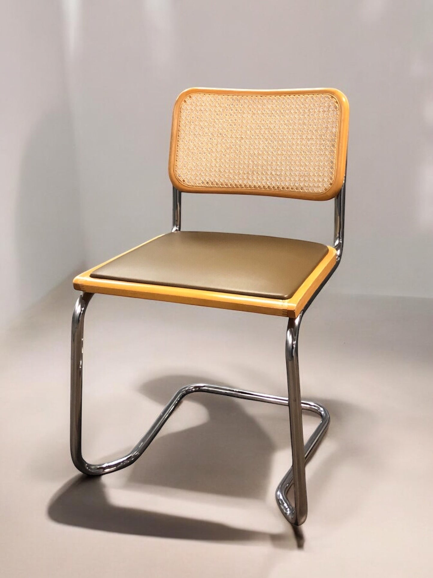 Rottingstol Klassisk Bauhausstolar med fodrad khaki konstläder sits och rotting rygg.
Sits märkt "Made in italy". 
Bra begagnat skick och stapelbar. Cesca  stol med flätad rotting. Designstol i klassisk stil. 
Designstol Frisvinger karmstol i klassiska design.
Höjd: ca 84,5 cm
Bredd: ca 48 cm
Djup: ca 52cm
Sitthöjd: ca 49 cm