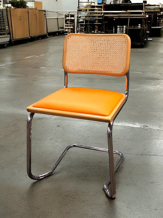 Rottingstol Klassisk Bauhausstolar med fodrad orange konstläder sits och rotting rygg.
Sits märkt "Made in italy". 
Bra begagnat skick och stapelbar. Cesca  stol med flätad rotting. Designstol i klassisk stil. 
Designstol Frisvinger karmstol i klassiska design.
Höjd: ca 84,5 cm
Bredd: ca 48 cm
Djup: ca 52cm
Sitthöjd: ca 49 cm