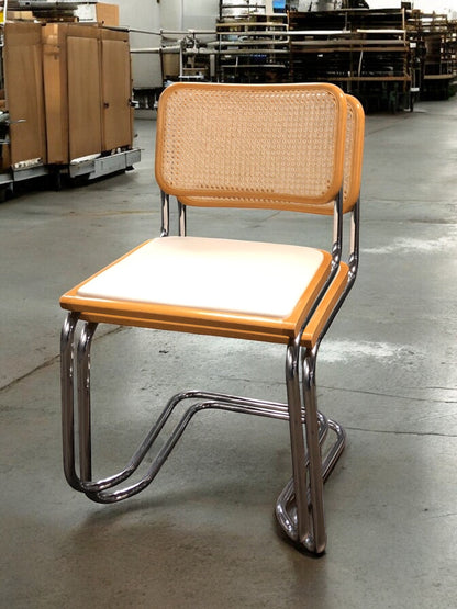 Rottingstol Klassisk Bauhausstolar med fodrad vit konstläder sits och rotting rygg.
Sits märkt "Made in italy". 
Bra begagnat skick och stapelbar. Cesca  stol med flätad rotting. Designstol i klassisk stil. 
Designstol Frisvinger karmstol i klassiska design.
Höjd: ca 84,5 cm
Bredd: ca 48 cm
Djup: ca 52cm
Sitthöjd: ca 49 cm