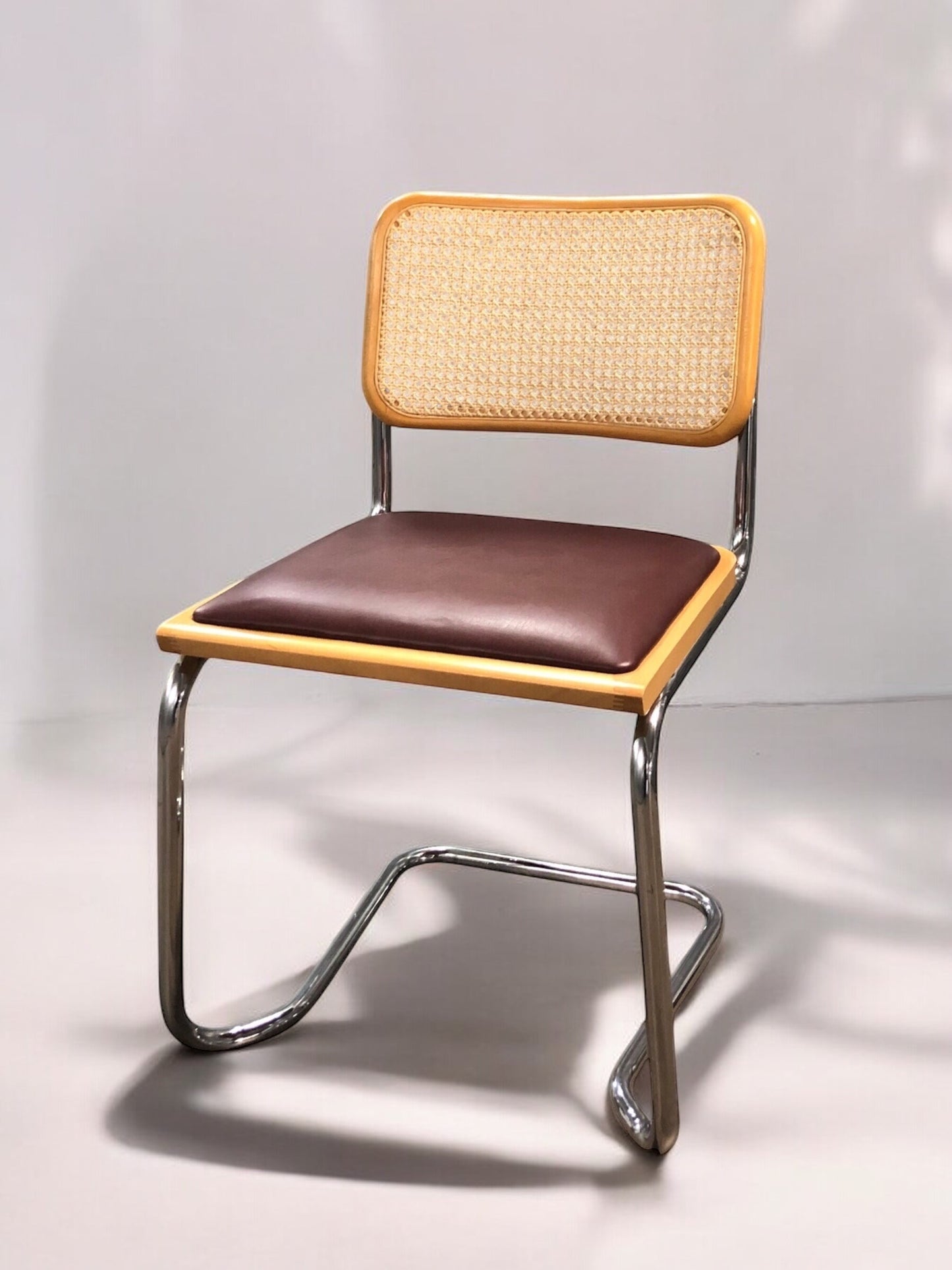 Rottingstol Klassisk Bauhausstolar med fodrad vinröd konstläder sits och rotting rygg.
Sits märkt "Made in italy". 
Bra begagnat skick och stapelbar. Cesca  stol med flätad rotting. Designstol i klassisk stil. 
Designstol Frisvinger karmstol i klassiska design.
Höjd: ca 84,5 cm
Bredd: ca 48 cm
Djup: ca 52cm
Sitthöjd: ca 49 cm