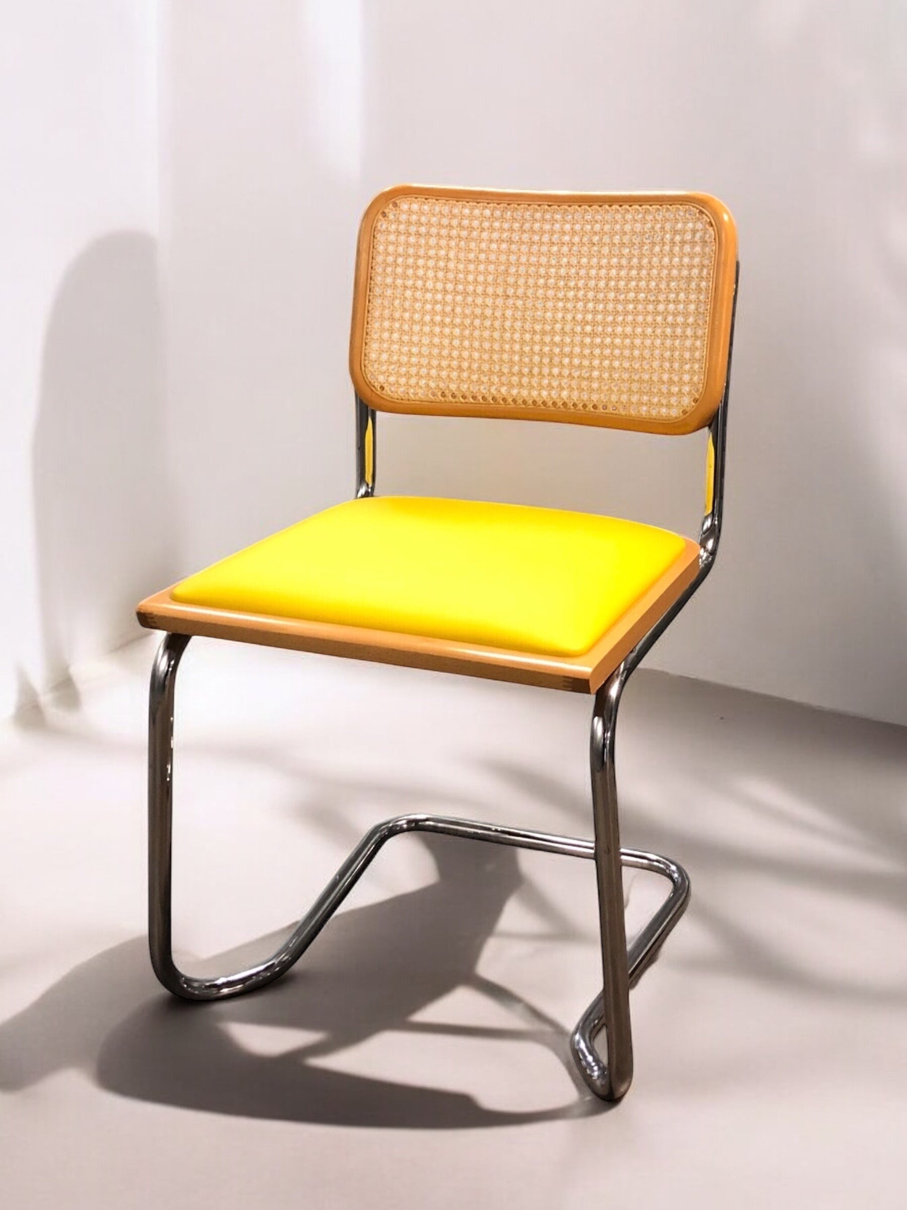 Rottingstol Klassisk Bauhausstolar med fodrad gul konstläder sits och rotting rygg.
Sits märkt "Made in italy". 
Bra begagnat skick och stapelbar. Cesca  stol med flätad rotting. Designstol i klassisk stil. 
Designstol Frisvinger karmstol i klassiska design.
Höjd: ca 84,5 cm
Bredd: ca 48 cm
Djup: ca 52cm
Sitthöjd: ca 49 cm