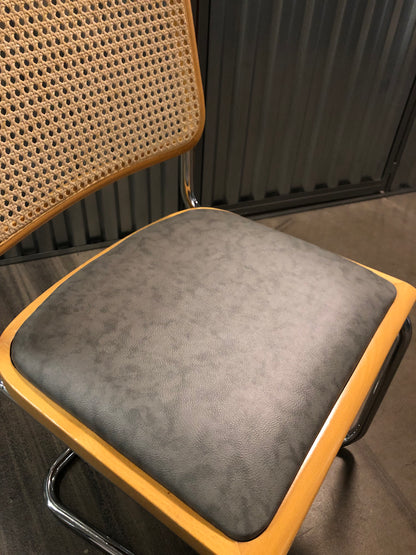 Rottingstol Klassisk Bauhausstol med fodrad gråmelerad konstläder sits och rotting rygg.
Sits märkt "Made in italy". 
Bra begagnat skick och stapelbar. Cesca  stol med flätad rotting. Designstol i klassisk stil. 
Designstol Frisvinger karmstol i klassiska design.
Höjd: ca 84,5 cm
Bredd: ca 48 cm
Djup: ca 52cm
Sitthöjd: ca 49 cm