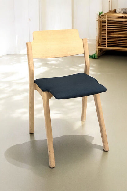 Stapelbar designstol i svensk design i grön/blå färg med ben i ljus ek och modern form – en slitstark, stilren stol perfekt för kök, matsal, kontor, konferensrum och modern skandinavisk inredning.