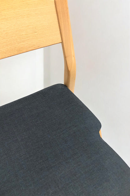 Stapelbar designstol i svensk design i grön/blå färg med ben i ljus ek och modern form – en slitstark, stilren stol perfekt för kök, matsal, kontor, konferensrum och modern skandinavisk inredning.