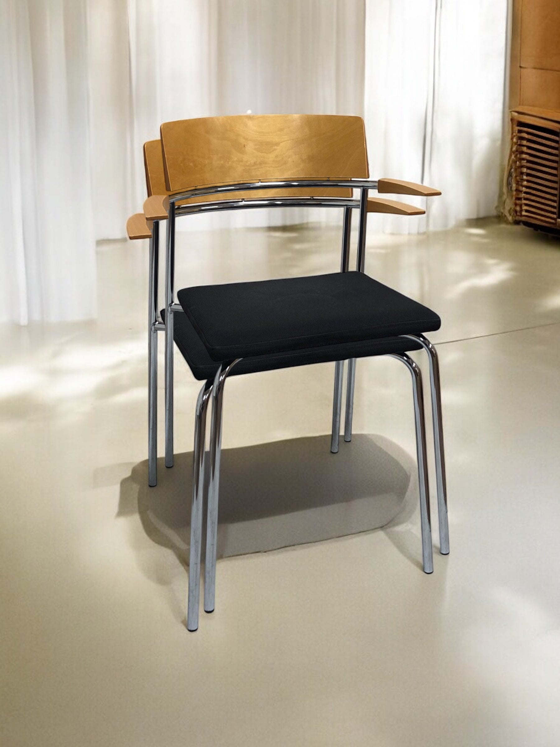 Elegant stol i ek med bekväma armstöd och fodrad sits – en stilren och ergonomisk matstol eller konferensstol i skandinavisk design, perfekt för matsal, mötesrum och moderna arbetsmiljöer.