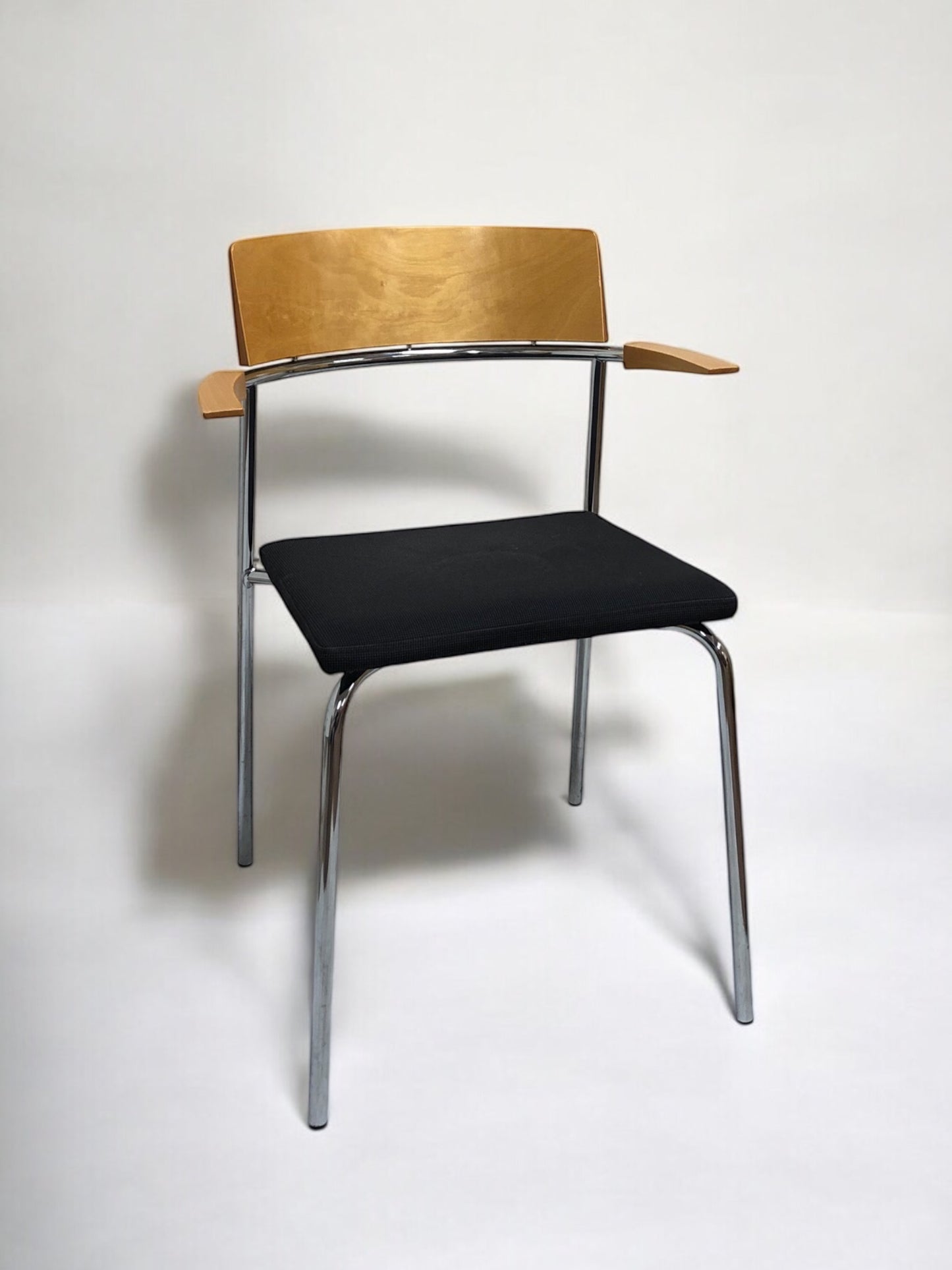 Elegant stol i ek med bekväma armstöd och fodrad sits – en stilren och ergonomisk matstol eller konferensstol i skandinavisk design, perfekt för matsal, mötesrum och moderna arbetsmiljöer.